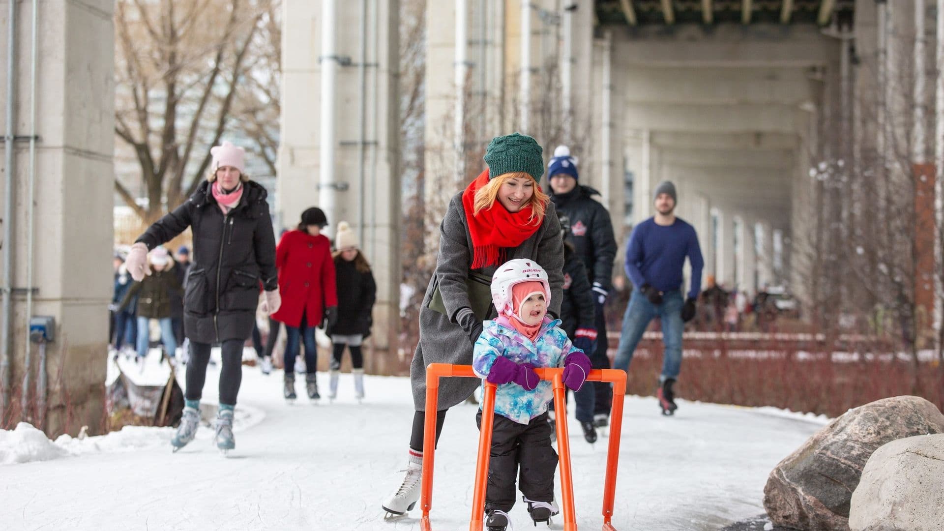 The Bentway children and parent skating under gardiner